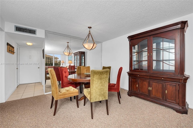 carpeted dining space featuring a textured ceiling