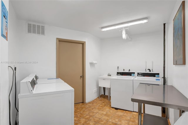 laundry room featuring washing machine and clothes dryer and sink