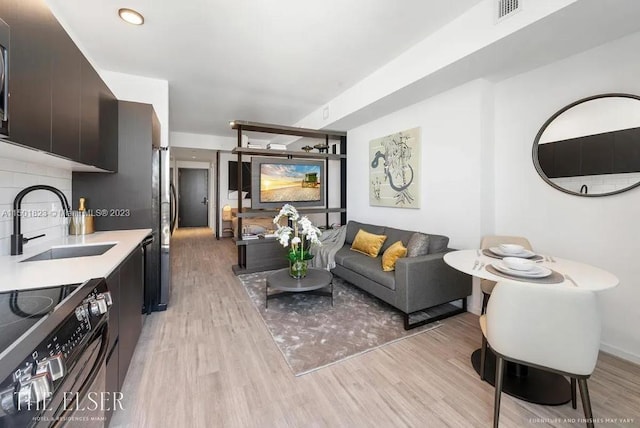 living room with sink and light hardwood / wood-style flooring