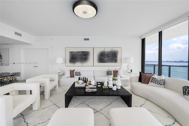 living room featuring a wall of windows and a water view