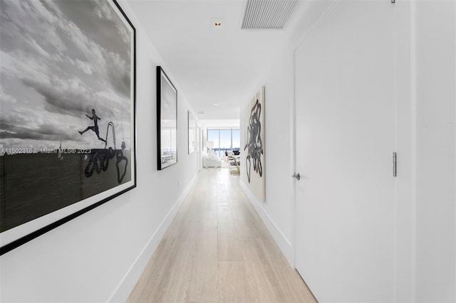 hallway with light hardwood / wood-style floors