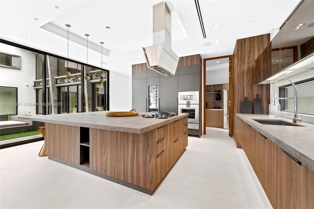 5245 Oak Ln, Coral Gables, FL 33156 - kitchen with modern cabinets, island exhaust hood, a large island, open shelves, and decorative light fixtures