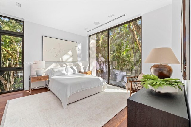 5245 Oak Ln, Coral Gables, FL 33156 - bedroom featuring expansive windows, wood finished floors, and access to exterior