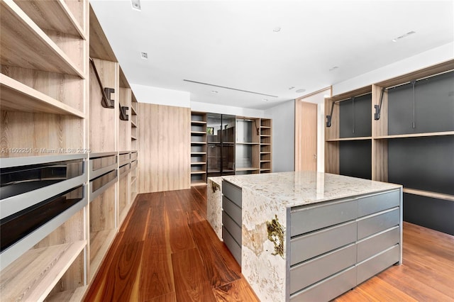 walk in closet with dark wood-type flooring