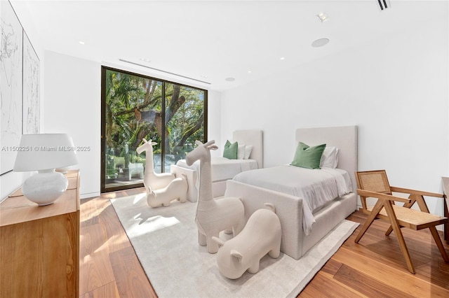 bedroom featuring wood-type flooring and expansive windows