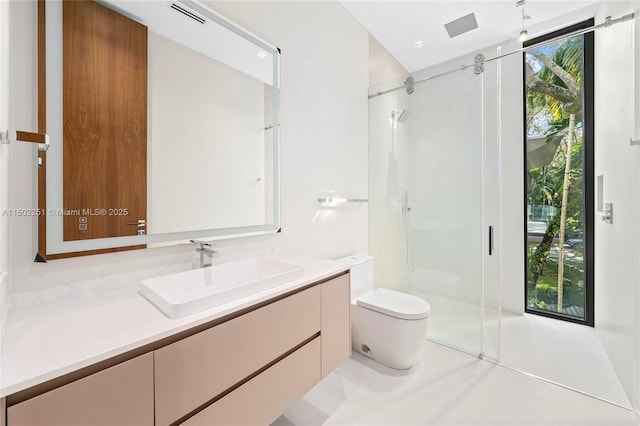 bathroom featuring tile patterned floors, vanity, toilet, and a shower with shower door