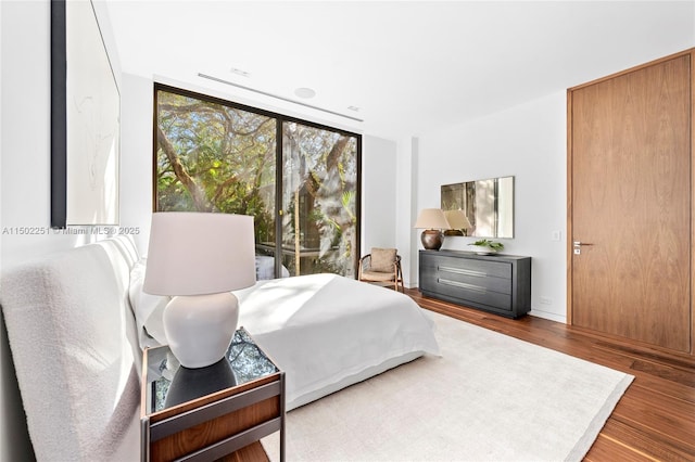 bedroom featuring hardwood / wood-style flooring and floor to ceiling windows