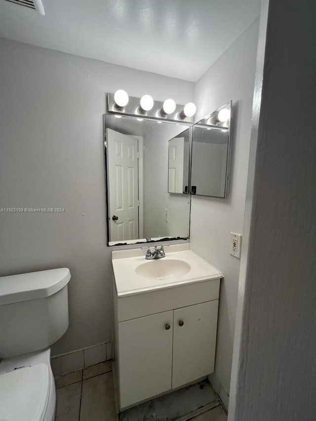 bathroom featuring tile patterned floors, vanity, and toilet