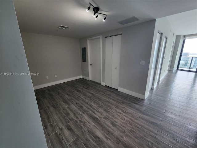 unfurnished bedroom featuring electric panel and dark wood-type flooring