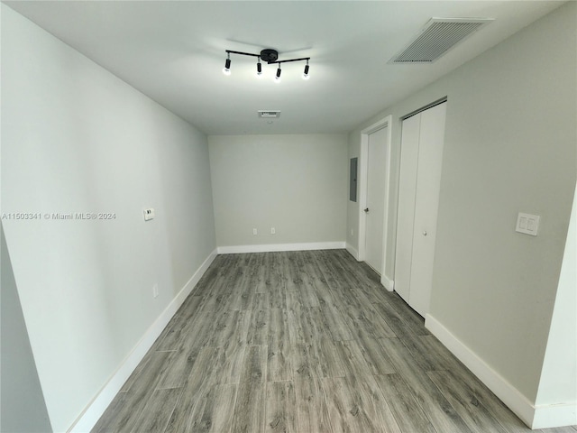 unfurnished bedroom featuring electric panel, a closet, and light hardwood / wood-style floors