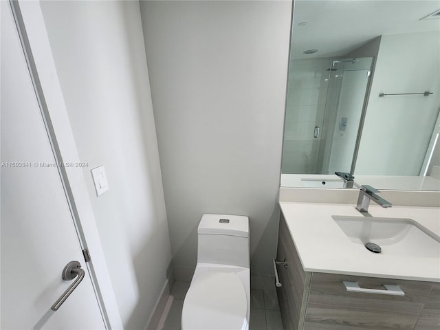 bathroom with tile patterned floors, vanity, toilet, and an enclosed shower