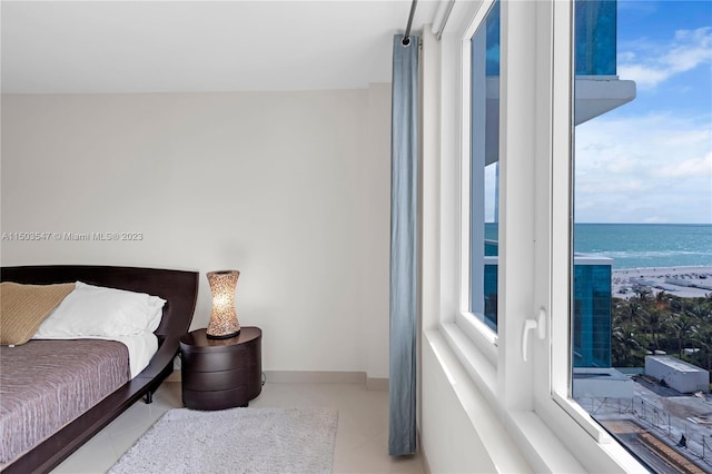 bedroom featuring tile patterned floors and a water view