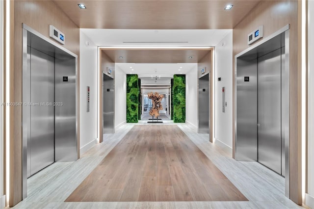 hallway featuring elevator and light wood-type flooring