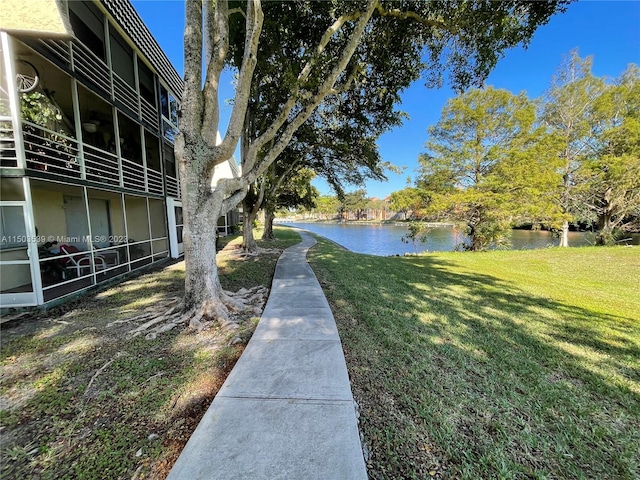 view of community featuring a water view and a yard