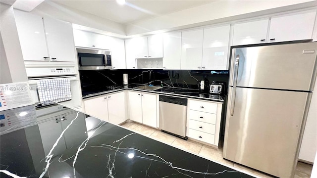 kitchen featuring stainless steel appliances, sink, white cabinets, and backsplash