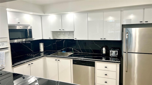 kitchen featuring white cabinetry, sink, backsplash, and stainless steel appliances