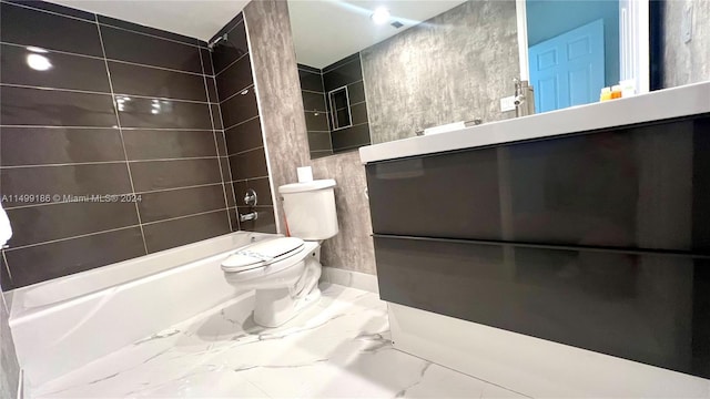 full bathroom featuring vanity, tile walls, toilet, and tiled shower / bath