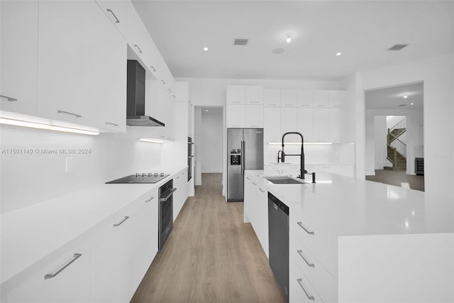 5735 SW 104th Ter, Cooper City, FL 33328 - kitchen with wall chimney exhaust hood, white cabinetry, appliances with stainless steel finishes, and light wood-type flooring
