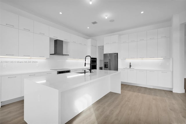 5735 SW 104th Ter, Cooper City, FL 33328 - kitchen with an island with sink, light hardwood / wood-style flooring, wall chimney exhaust hood, and high end refrigerator