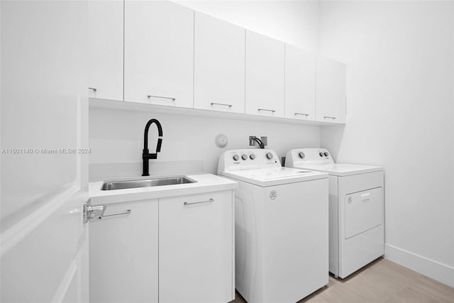 5735 SW 104th Ter, Cooper City, FL 33328 - clothes washing area with cabinets, sink, washing machine and dryer, and light hardwood / wood-style flooring