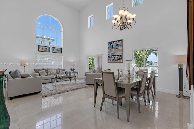 dining room featuring a chandelier, a towering ceiling, and light tile floors