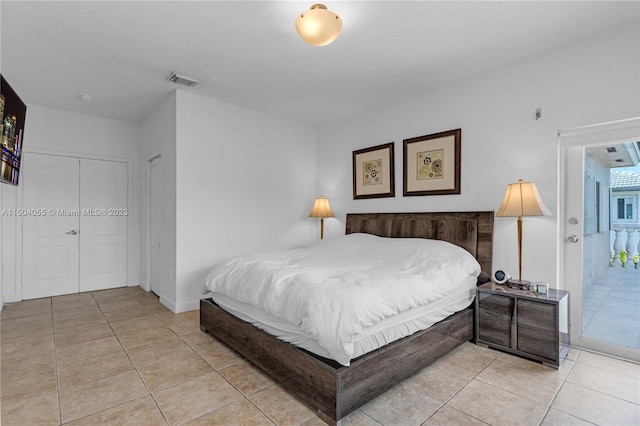 tiled bedroom featuring a closet and access to exterior