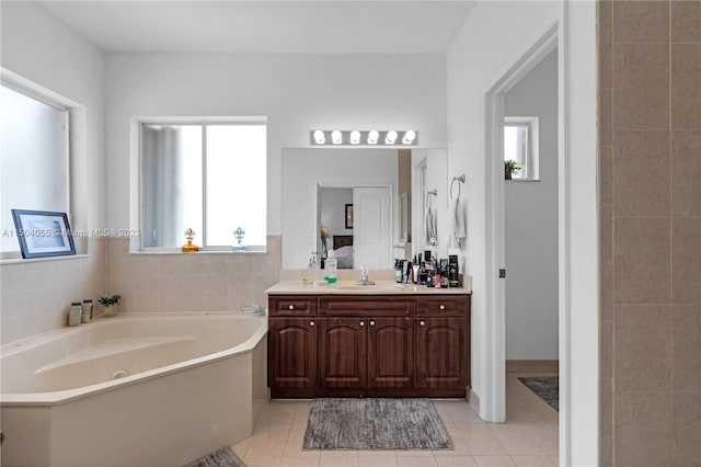 bathroom with a tub, tile flooring, vanity, and tile walls