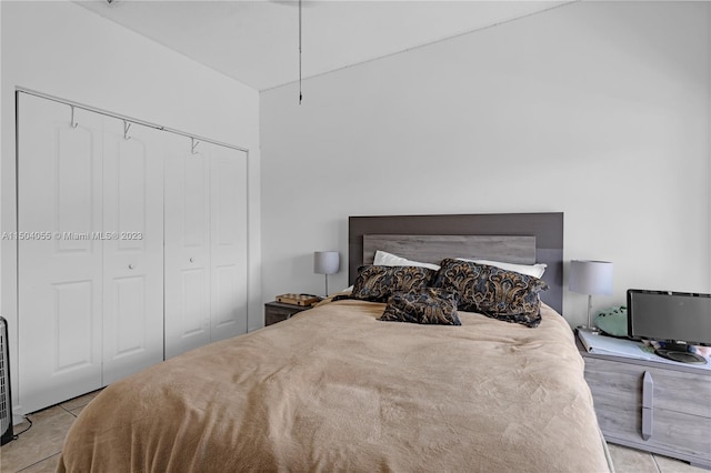 bedroom with a closet and light tile floors