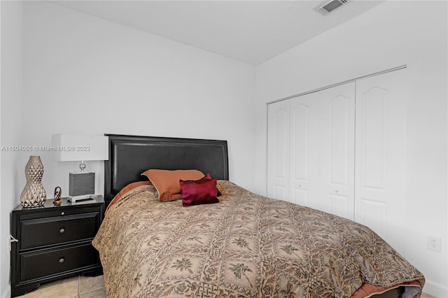 bedroom with a closet and light tile floors