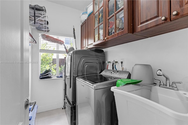 clothes washing area with washing machine and clothes dryer, washer hookup, light tile floors, sink, and cabinets