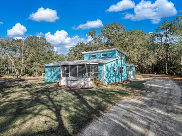 view of front of property featuring a sunroom and a front yard