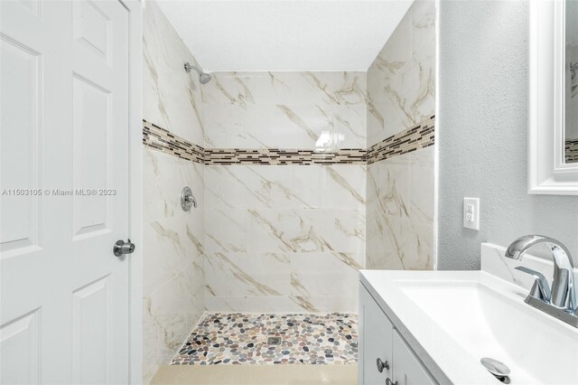 bathroom featuring vanity and a tile shower