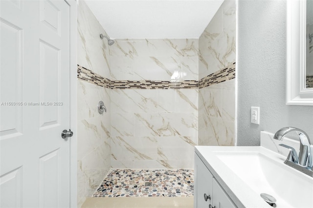 104 Ballard, Avon Park, FL 33825 - bathroom featuring tiled shower, vanity, and a textured wall
