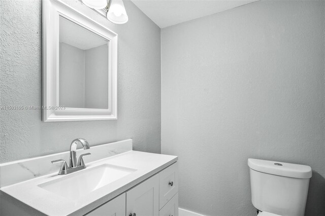 104 Ballard, Avon Park, FL 33825 - half bathroom with vanity, toilet, and a textured wall
