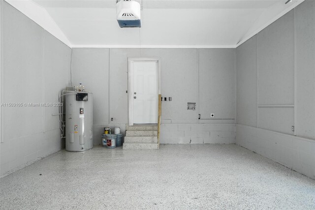 104 Ballard, Avon Park, FL 33825 - garage featuring electric water heater, a garage door opener, and concrete block wall