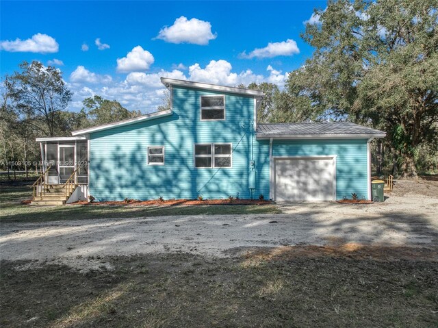 104 Ballard, Avon Park, FL 33825 - view of front of home with an attached garage, driveway, a sunroom, metal roof, and entry steps