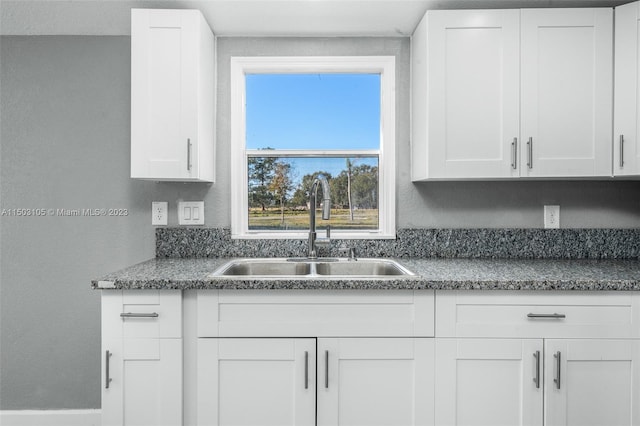 kitchen featuring sink and white cabinets