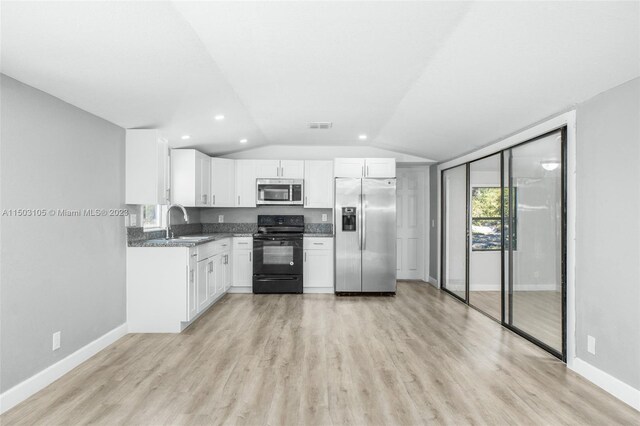 104 Ballard, Avon Park, FL 33825 - kitchen featuring stainless steel appliances, a sink, vaulted ceiling, baseboards, and white cabinetry