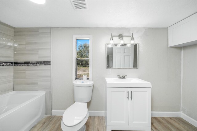 104 Ballard, Avon Park, FL 33825 - bathroom with wood finished floors, toilet, vanity, and baseboards