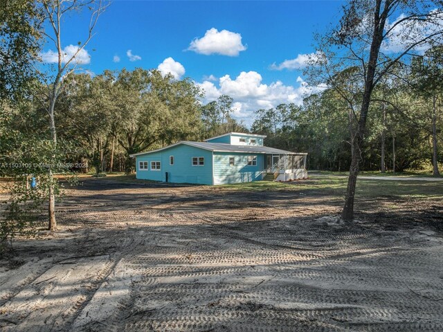 104 Ballard, Avon Park, FL 33825 - view of front of home with driveway and view of wooded area