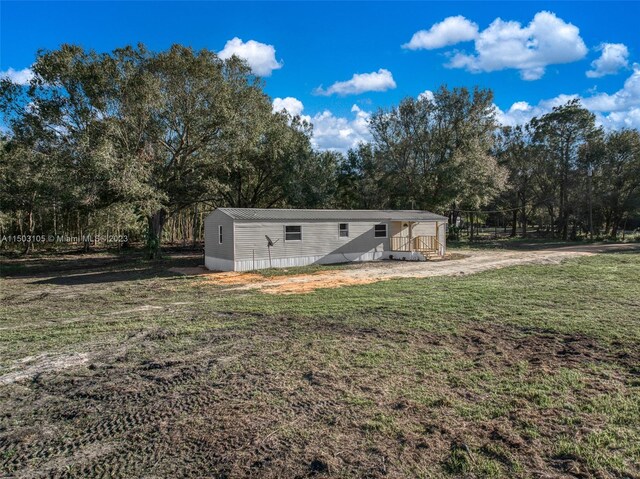 104 Ballard, Avon Park, FL 33825 - rear view of property with a lawn, view of wooded area, and entry steps
