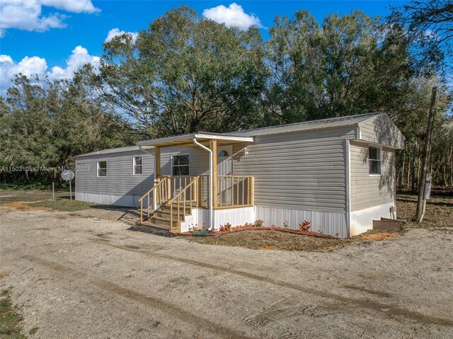 104 Ballard, Avon Park, FL 33825 - view of front of property with view of wooded area and metal roof