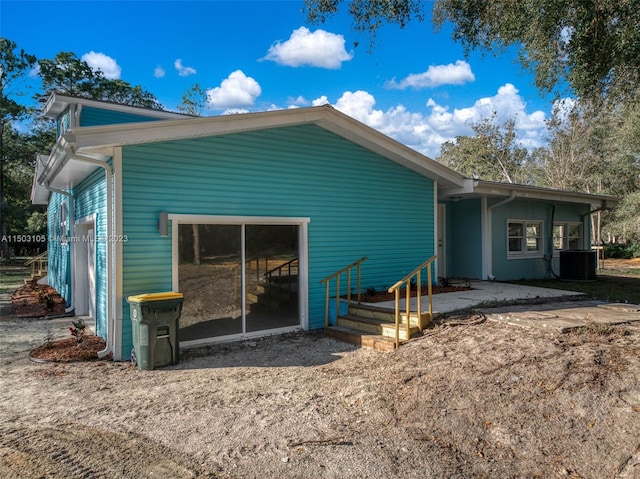 rear view of property with central AC