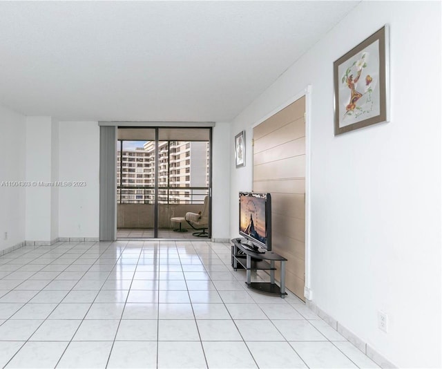 unfurnished living room with floor to ceiling windows and light tile patterned floors