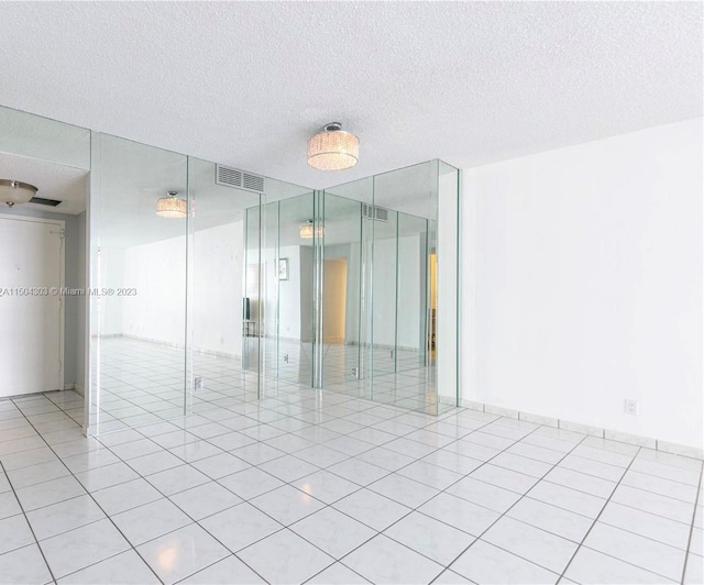 empty room with light tile patterned flooring and a textured ceiling