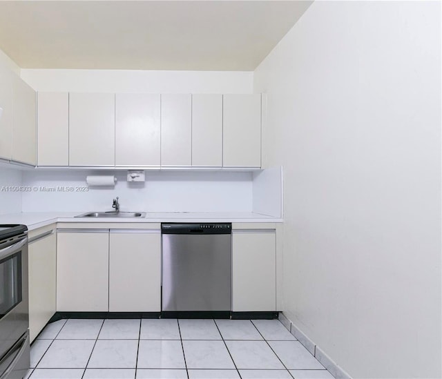 kitchen featuring appliances with stainless steel finishes, white cabinetry, light tile patterned floors, and sink