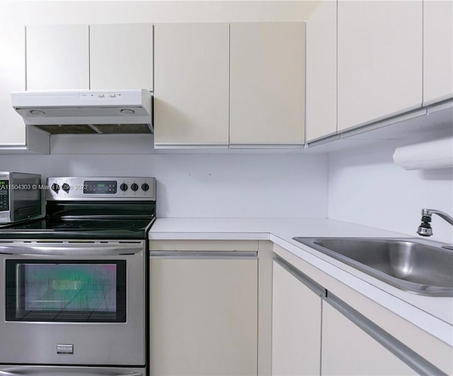 kitchen with sink, white cabinetry, and stainless steel electric range