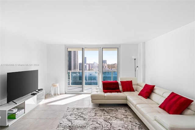 living room with floor to ceiling windows and light tile patterned floors