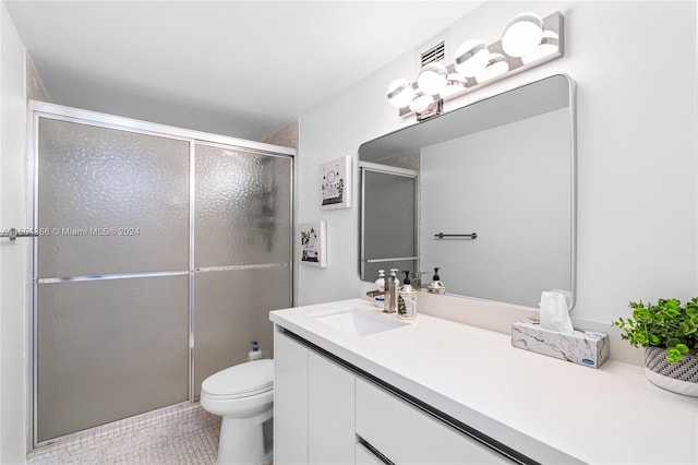 bathroom featuring tile patterned flooring, walk in shower, toilet, and vanity