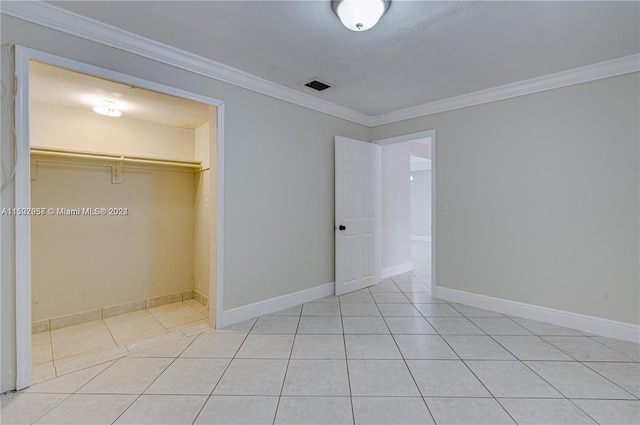 unfurnished bedroom with a closet, light tile flooring, and ornamental molding